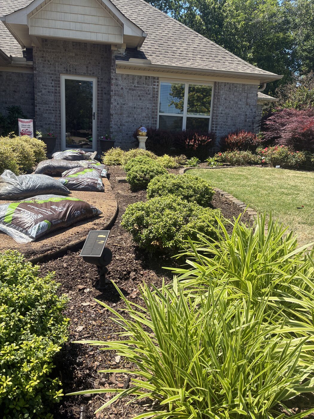Brick home landscaping during a fresh mulch installation
